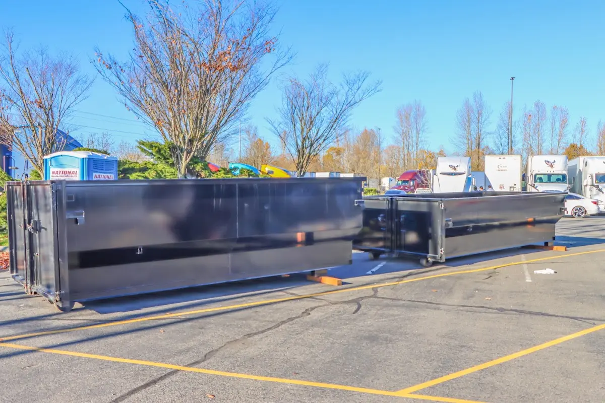 Professional dumpster rental service with roll-off container on residential driveway in East Aurora